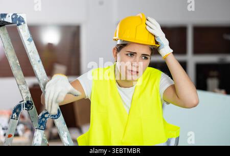 Sad woman builder standing in construction site Stock Photo