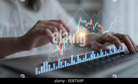 A close-up view of hands interacting with financial data on a laptop, featuring a digital chart that shows stock market trends and analytics in a Stock Photo