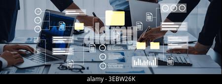 A dynamic office scene depicting collaborative teamwork with laptops and digital documents, focusing on effective communication and project planning Stock Photo