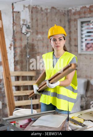 Female carrying wooden panel on construction site Stock Photo