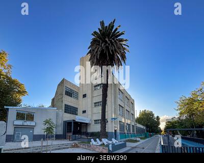 UBA Drago university headquarters in Buenos Aires, highlighting its functionalist architecture, a central palm tree and the urban environment. Stock Photo