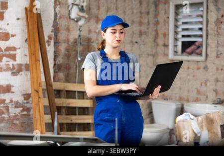 Female engineer using laptop in apartment Stock Photo