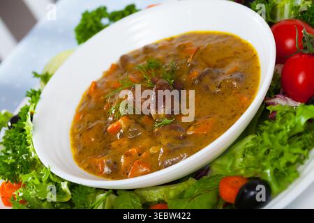 Delicious cooked goulash from chicken hearts served with vegetables Stock Photo