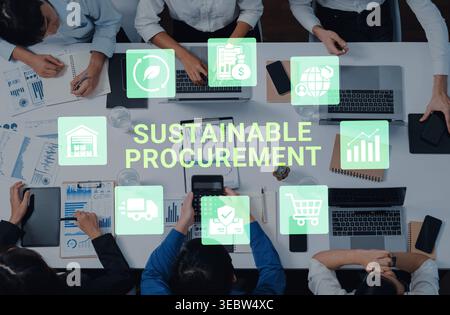 A diverse team collaborates on sustainable procurement strategies using digital tools and graphics, showcasing modern office dynamics and Stock Photo