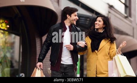 Young Couple Enjoys Shopping Together in Urban Setting on a Sunny Day Stock Photo