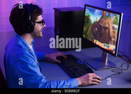 Enthusiastic Gamer Enjoying an Immersive Experience While Playing on a Computer Setup Stock Photo