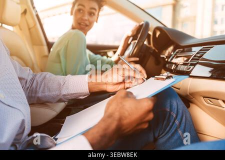 Driving Instructor Writing Down Results Of Exam Stock Photo