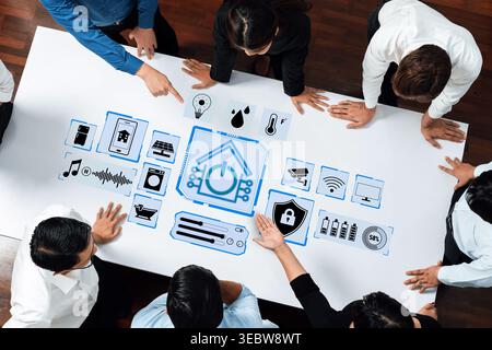 Collaborative Team Meeting on Smart Home Technology with Diverse Professionals Engaging Over Digital Interface and Icons Representing Home Automation Stock Photo