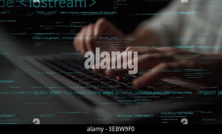 A close-up view of hands typing on a laptop keyboard surrounded by flowing computer code. This image captures the essence of software development in a Stock Photo