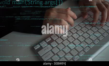 A close-up view of a programmer hands typing on a computer keyboard, creating code for software development. The image symbolizes technology and Stock Photo