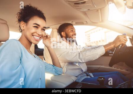 Happy Couple Drives Together During Sunny Day in a Car Stock Photo