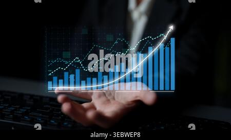 A professional analyzes digital graphs and charts representing financial growth trends in a modern office. This image illustrates strategic planning Stock Photo