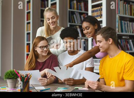Group of Students Collaborate on Creative Project in Library During Daylight Hours Stock Photo