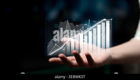 A digital representation of analytics is shown in a hand. Graphs and charts illustrate financial growth and progress, emphasizing modern business Stock Photo
