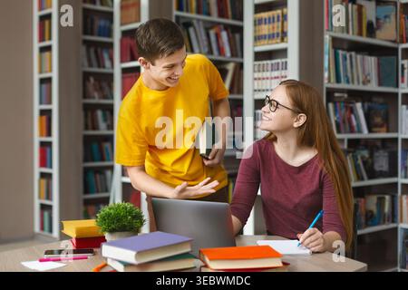 Students Collaborate on Study Project in a Library Setting During Daytime Stock Photo