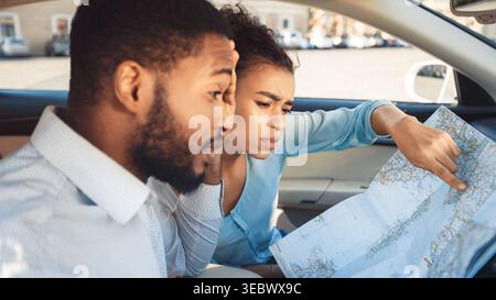 Couple Exploring Travel Plans While Sitting in Car Using a Map Stock Photo