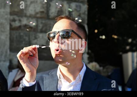 Headshot of a man blowing soap bubbles at a wedding Stock Photo