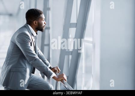 Feeling Relaxed. Confident Businessman Looking Through Window Stock Photo