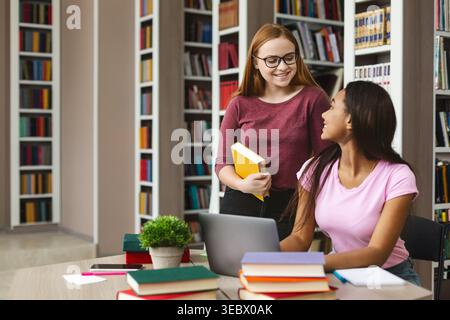 Students Collaborate in a Library While Studying and Sharing Resources in a Learning Environment Stock Photo