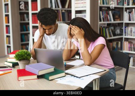 Students Experiencing Stress While Studying Together in a Library Environment Stock Photo