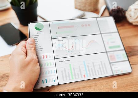 Digital business chart displayed on a tablet while a person interacts with it in an office Stock Photo