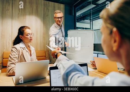 Team collaborates confidently in contemporary glass office environment Stock Photo