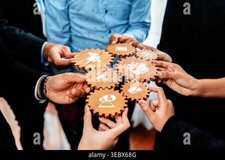 A dynamic team collaborates using wooden gears to symbolize strategic business concepts, fostering an interactive environment for creative problem Stock Photo