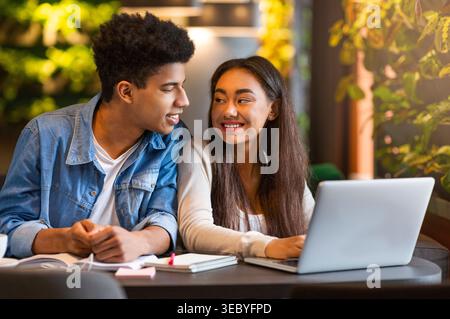 Young Students Collaborate at a Cozy Cafe on School Project During Afternoon Stock Photo