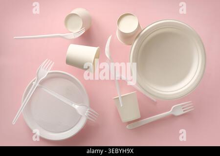 White plastic tableware levitating on pink background Stock Photo