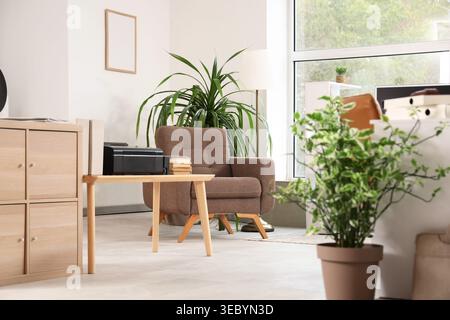Interior of light office with armchair, printer and drawers Stock Photo
