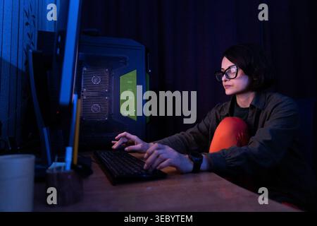 Woman Working on Desktop Computer in Low Light Stock Photo
