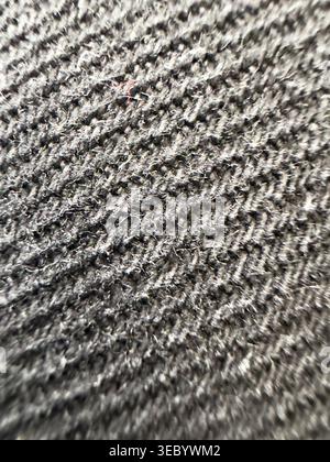 Macro photography captures the detailed weave of dark grey textile material with individual threads and soft fibers visible, conveying warmth and text Stock Photo