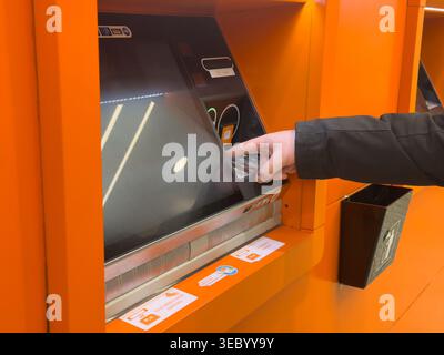 Krakow, Poland - December 3, 2025: A close-up shows a hand pressing buttons on an ATM keypad, facilitating secure and easy financial operations for th Stock Photo
