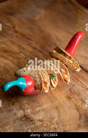 These enticing mini tacos, presented creatively in a bright chili holder, promise a burst of authentic Mexican flavors. A delightful and visually appe Stock Photo