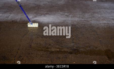 Paint roller applying primer coating on concrete floor Stock Photo
