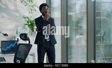 Pensive African American business man thinking in office looking out window create solution ethnic businessman male professional think idea decide Stock Photo