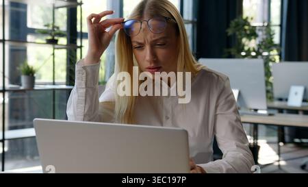 Caucasian business woman browsing laptop focusing on screen monitor bad vision blurry see businesswoman female girl with computer modern cyberspace Stock Photo