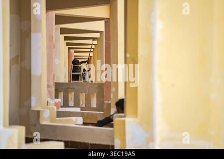 Marsa alam, egypt 21 april 2026: construction workers painting building interior walls, showing renovation and labor in new construction with repeatin Stock Photo