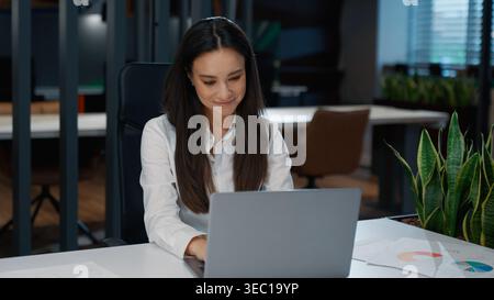 Motivated Caucasian business woman typing laptop technology service chatting online smiling busy businesswoman working with computer device female Stock Photo