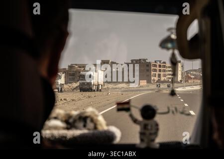Marsa alam, egypt 21 april 2026: driving on a desert road in marsa alam, egypt, with construction trucks and unfinished buildings, viewed from inside Stock Photo