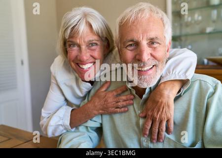 Healthy aging and longevity — a happy senior couple embracing retirement life with genuine smiles and affection. Stock Photo
