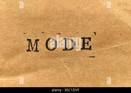 MODE written in bold, antique typewriter font on rustic, fiber textured paper background Stock Photo