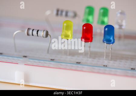Electronics prototyping with LEDs and resistor on breadboard, close-up circuit components Stock Photo