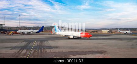 Several commercial airplanes are parked on the tarmac of a large airport Stock Photo