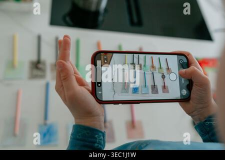 Hands holding smartphone taking a photo of objects. Concept of mobile photography, social media content creation, and modern technology use. Stock Photo