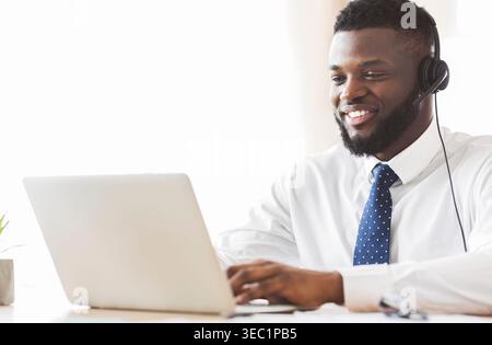 Young business consultant typing email to client on laptop Stock Photo