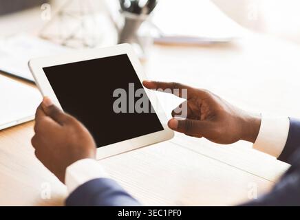Black man using digital tablet with blank screen Stock Photo
