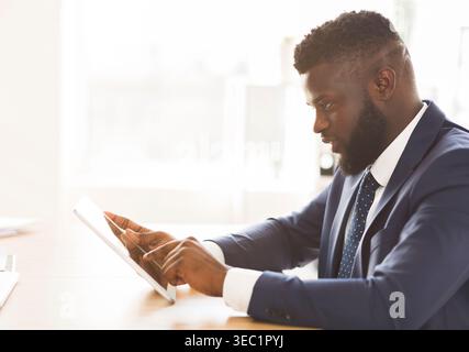 Young entrepreneur using business application on digital tablet Stock Photo