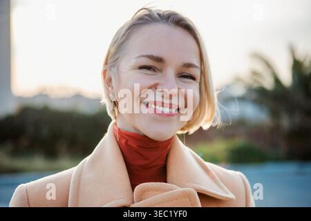 Portrait of young caucasian woman smiling outdoors Stock Photo
