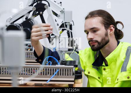 automation machine engineer students study and adjusting control robot arm machine in robotics engineering academy at university or factory workshop. Stock Photo